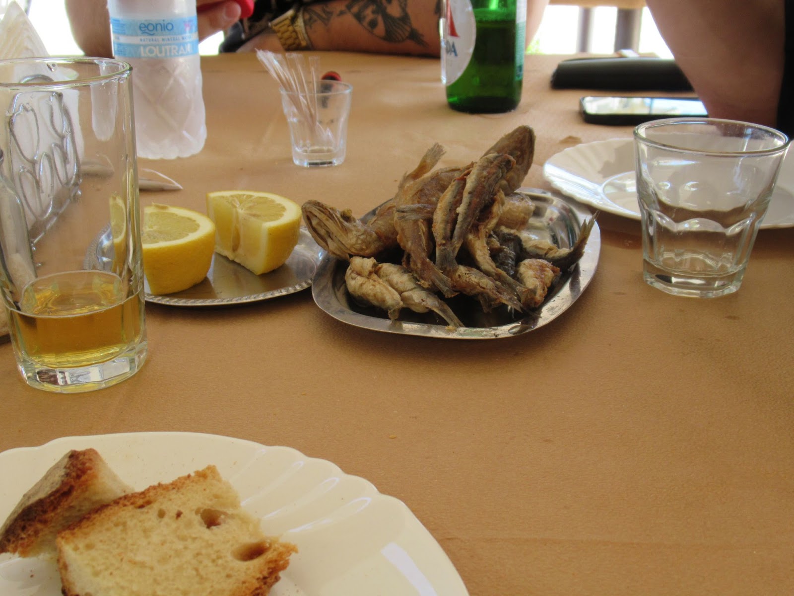 Griechische Vorspeise mit Olivenöl, frittiertem Fisch, Brot und Zitrone